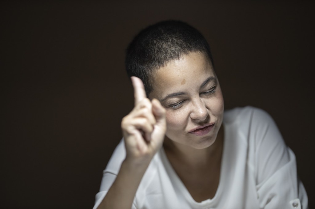 A woman raising a finger to raise a point
