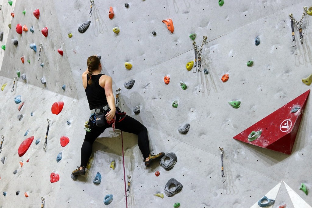  man climbs to top of climbing wall